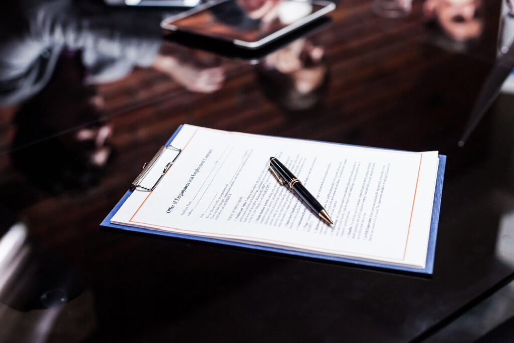 The pad with the documents and pen lying on the office table.